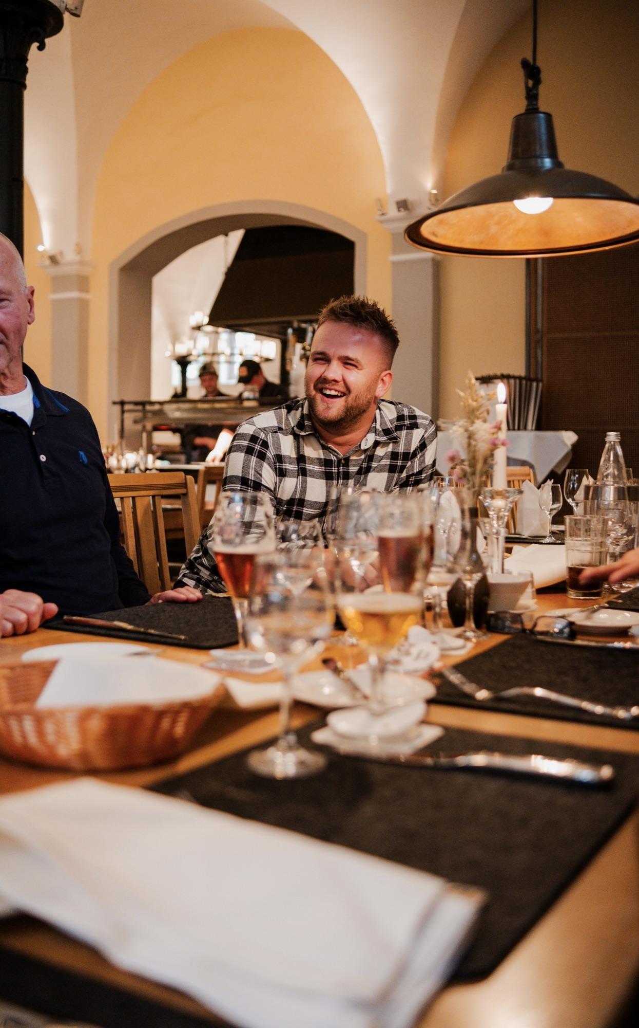 Dinner at a long table, a guest laughing mid-conversation