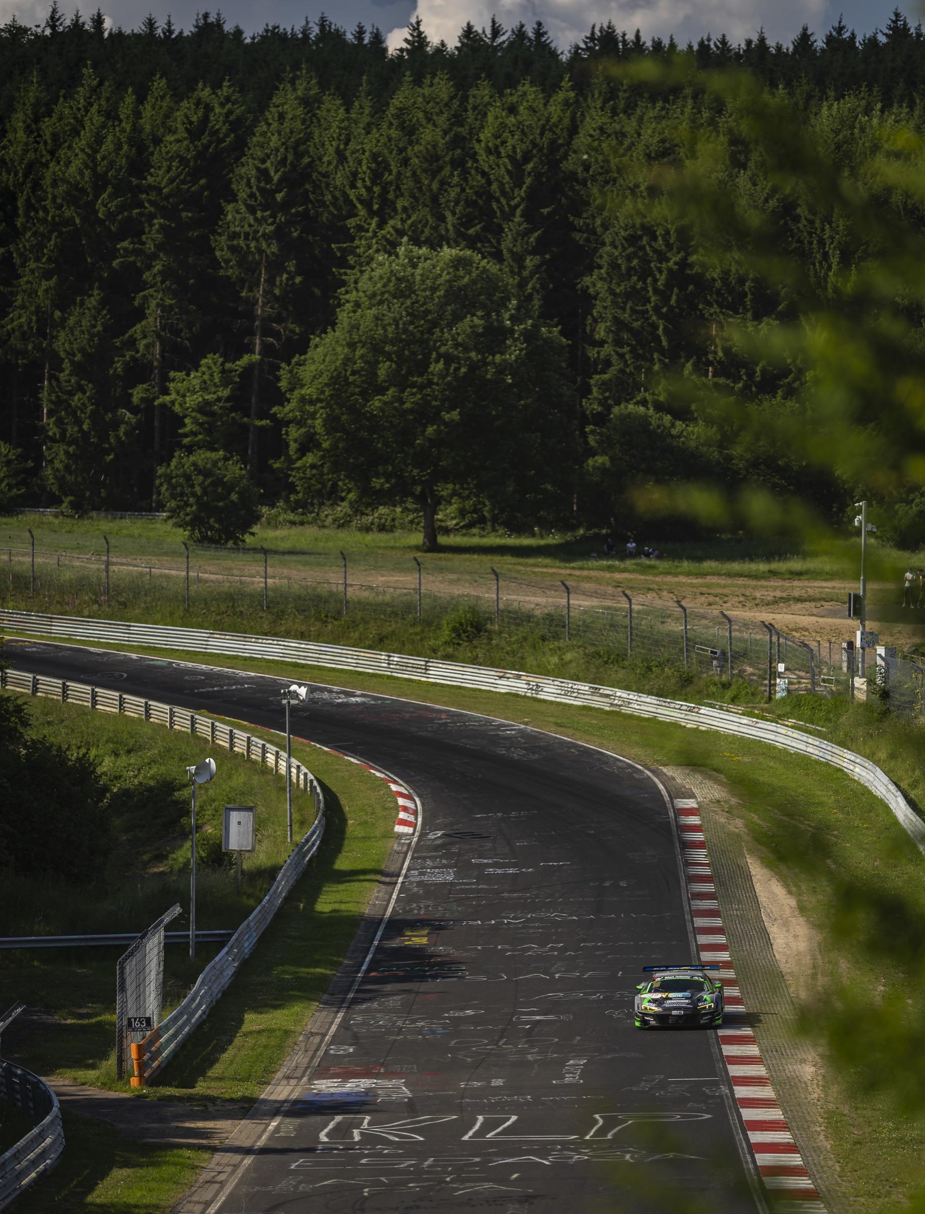 Audi R8 LMS GT3 on the Nordschleife with the track winding away through the forest